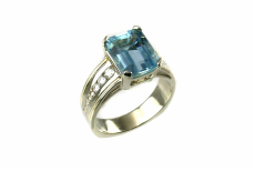 emerald-cut sky blue topaz, custom-designed 14-karat white gold ring with yellow gold braid accents, channel-set diamonds